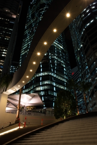 Looking up at night scene of high rise buildings and city lights - Australian Stock Image