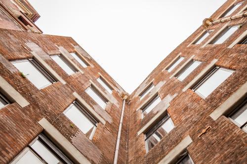 Looking up at old brick city buildings on overcast day - Australian Stock Image