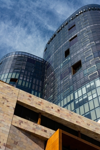 Looking up at unusual and patterned shapes of high rise buildings with dark blue sky - Australian Stock Image