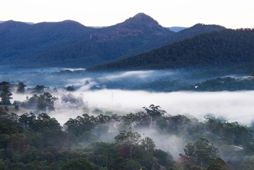 Lookout into misty valleys with mountains in the background. - Australian Stock Image