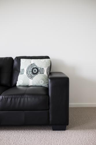 Lounge interior with black leather sofa - Australian Stock Image