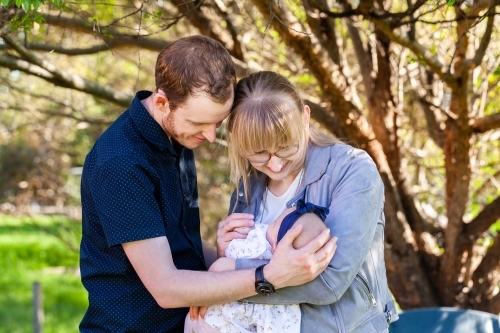 Loving first time parents doting on newborn daughter outside - Australian Stock Image