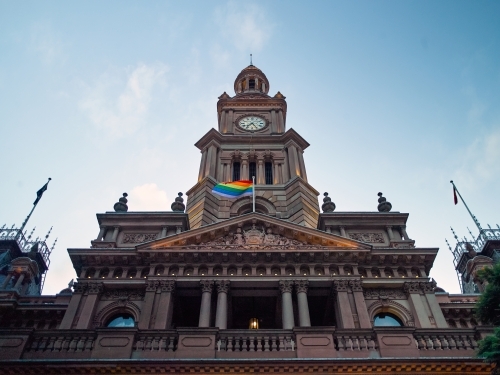 Low-angle shot of Sydney Town Hall with pride flag - Australian Stock Image