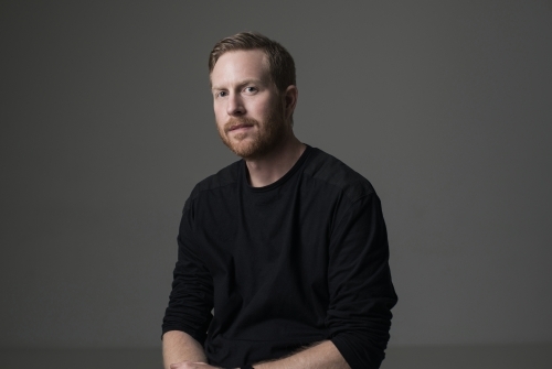 Low key portrait of young man in studio - Australian Stock Image