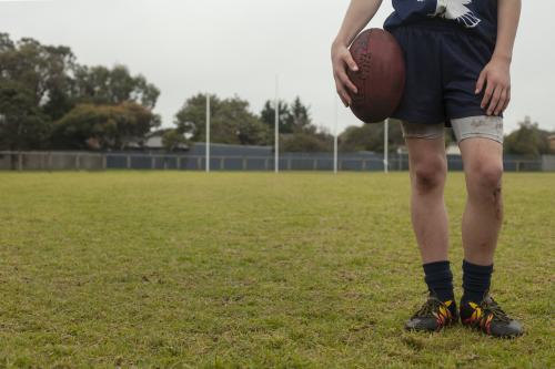 Low view of legs and torso of grassroots Footy player