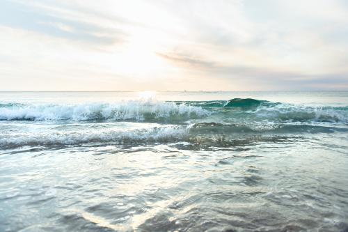 Low waves and pretty colours at the beach at sunset in summer