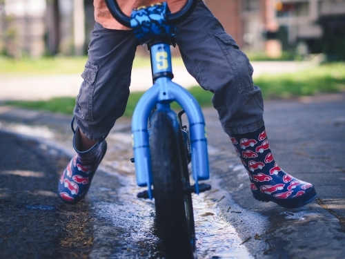 Lower view of child riding a bike - Australian Stock Image