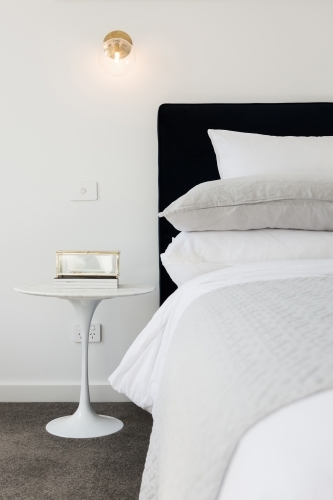 Luxe styled bedroom with gold wall sconce lighting - Australian Stock Image