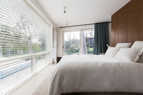Luxurious interior designed bedroom with amazing view of the pool and trees - Australian Stock Image