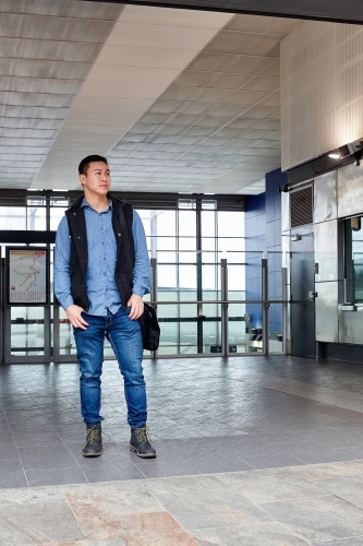 Male commuter waiting at train station entrance - Australian Stock Image
