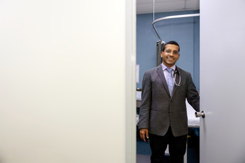 Male doctor opening clinic door - Australian Stock Image