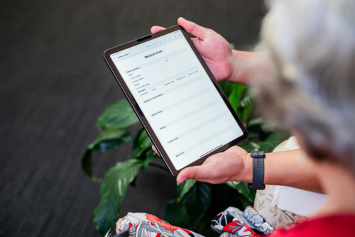 Male healthcare worker holding tablet device for an elderly woman - Australian Stock Image