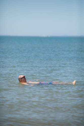 Male open water swimmer floating on back in water - Australian Stock Image