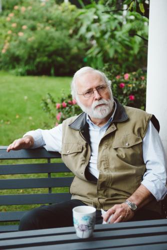 Male university teacher having a coffee break in the garden - Australian Stock Image