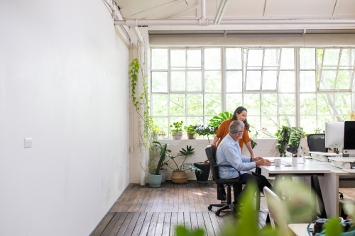 Man and woman meeting in an urban renovated white heritage office space - Australian Stock Image