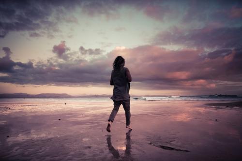 Man at the beach at dawn (high iso) - Australian Stock Image