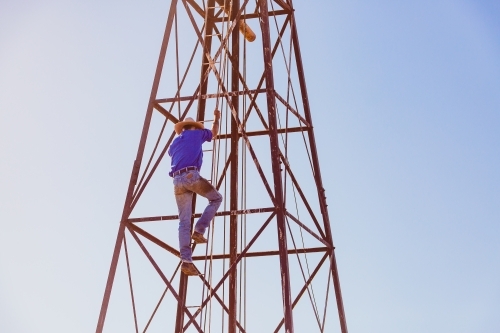 Man climbing windmill tower