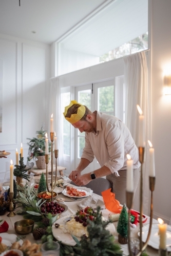Man deveining prawns at Christmas-decorated table - Australian Stock Image