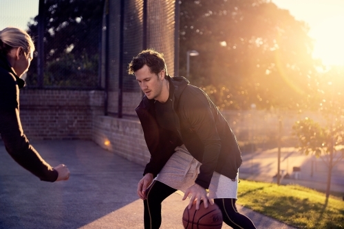 Man dribbling basketball in one on one game - Australian Stock Image