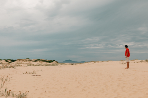 Man exploring sand dunes at Mungo Beach on the NSW coast - Australian Stock Image
