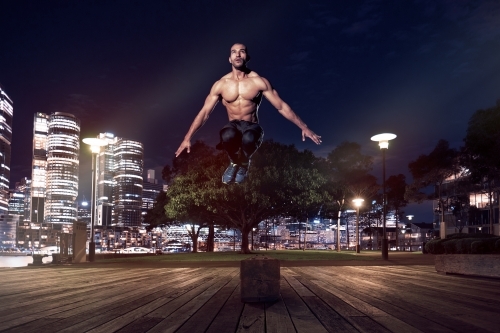 Man fitness training in urban area at night - Australian Stock Image
