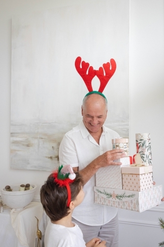 Man giving Christmas present to grandson - Australian Stock Image