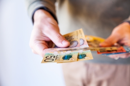 Man holding out fifty dollar notes - Australian Stock Image