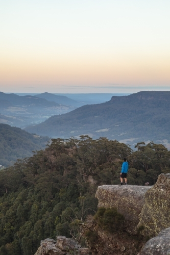Man in distance overlooking mountains - Australian Stock Image