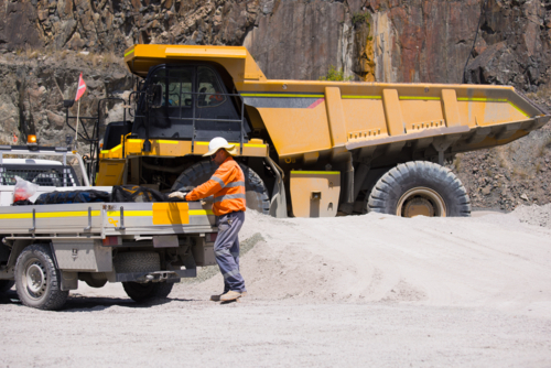Man in high visibility clothes standing at the back of ute on mine site - Australian Stock Image