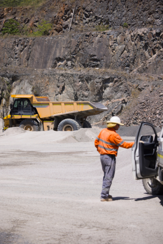 Man in high visibility clothing opening the door of his car. - Australian Stock Image