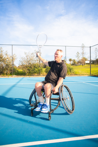 man in wheelchair on tennis court - Australian Stock Image