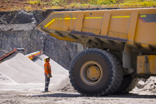 Man in workwear checking the back end of the hauler truck. - Australian Stock Image