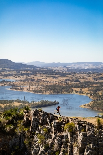 Man jumping on mountain ridge - Australian Stock Image