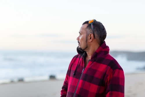 Man looking out to sea at dusk - Australian Stock Image