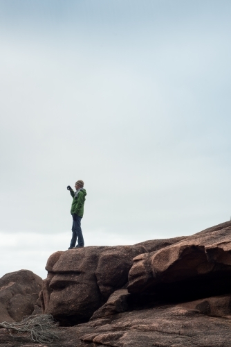 Man on boulder rocks at beach