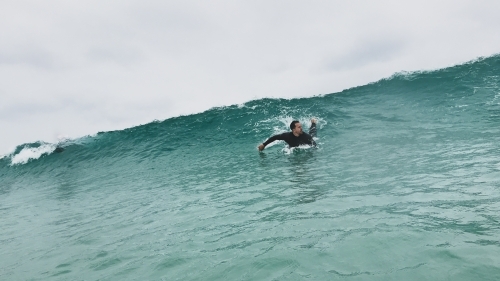man paddling for a wave surfing a short board taken in water - Australian Stock Image