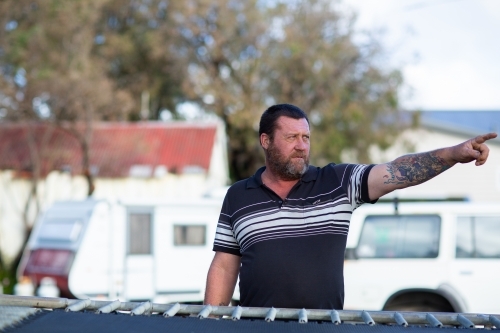 Man pointing with tattooed arm - Australian Stock Image