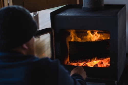 Man poking fireplace - Australian Stock Image