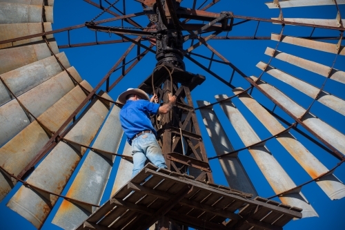 Man repairing windmill - Australian Stock Image