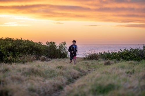 Man Running Away from Beach at Sunrise