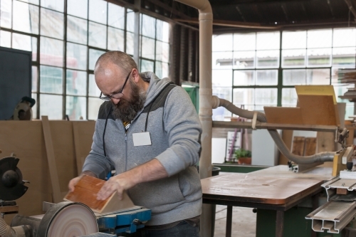 Man sanding wood at a men's shed - Australian Stock Image