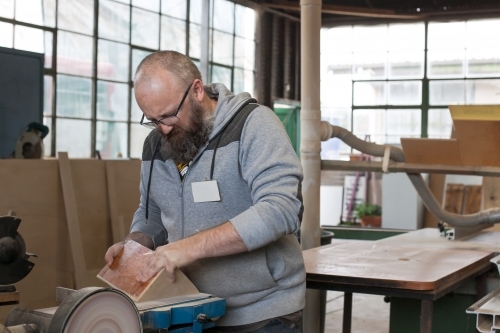 Man sanding wood at a Men's shed - Australian Stock Image