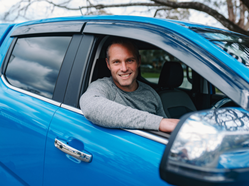 Man sitting inside blue car behind the wheel - Australian Stock Image