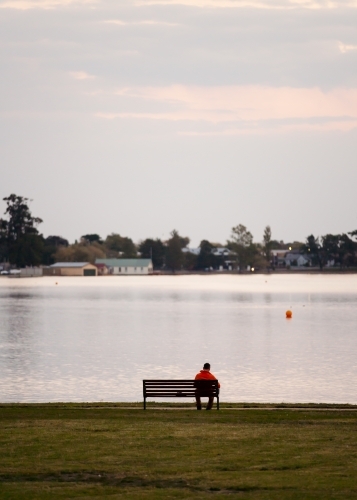 Man sitting on a bench seat at the lakeside