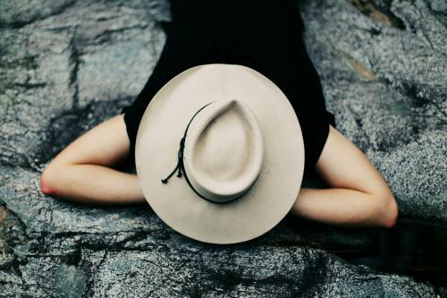 Man sleeping with hat on his face outdoors