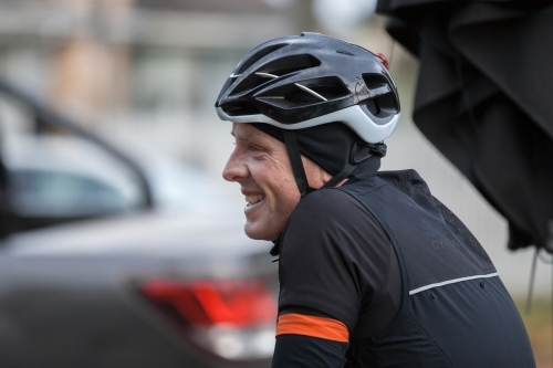 Man smiling at a cafe after a bike ride - Australian Stock Image