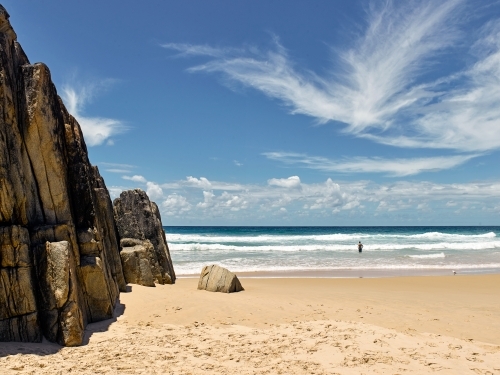 Man standing in the surf at the beach - Australian Stock Image
