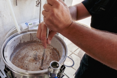 Man stirring beer mash - Australian Stock Image