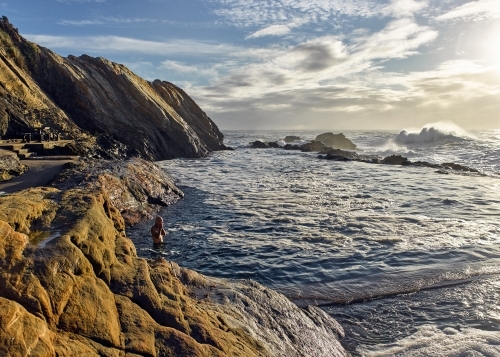 Man swimming at ocean pool in the early morning - Australian Stock Image