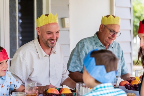 man wearing paper hat at Christmas family celebration - Australian Stock Image